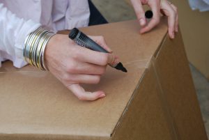 person writing on a box